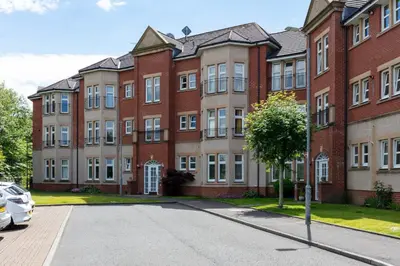 a large brick building with a car parked in front of it at 9A Millbrae - Donnini Apartments in Ayr