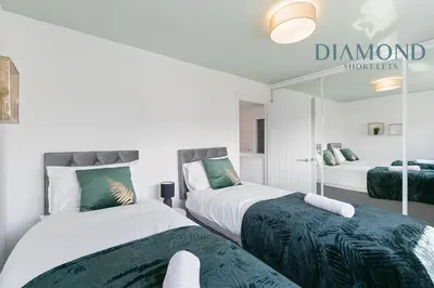 a bedroom with two beds and a mirror at Grangemouth, 3 Bed House, Free Parking, Business or Leisure in Grangemouth