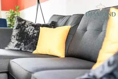 a gray couch with yellow pillows on it at Grangemouth, 3 Bed House, Free Parking, Business or Leisure in Grangemouth