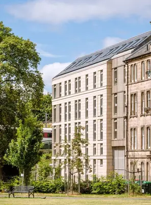 a building with a bench in front of it at Modern Studio Apartments at Murieston Crescent in Edinburgh in Edinburgh