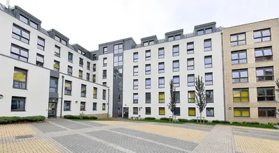 a row of apartment buildings with a courtyard at HFS The Mill House Edinburgh in Edinburgh