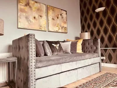 a living room with a gray couch with pillows at Apartment with City Views - Sleeps 3 in Edinburgh