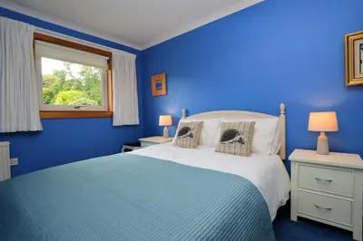 a blue bedroom with a bed and a window at Brookfield in Sandbank