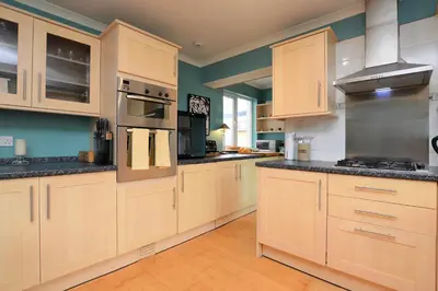 a large kitchen with wooden cabinets and stainless steel appliances at Brookfield in Sandbank