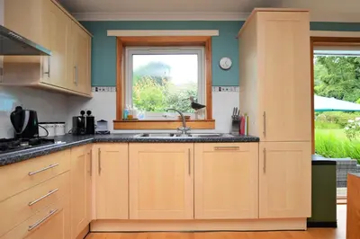 a kitchen with wooden cabinets and a sink and a window at Brookfield in Sandbank