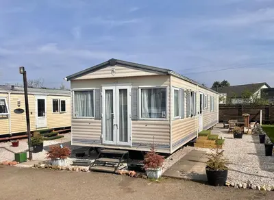 a white tiny house is parked in a lot at 2 Bedroom Caravan Located in Uddingston, Glasgow at Maryville Caravan Site in Uddingston
