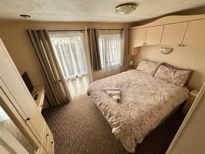 a small bedroom with a bed and a window at 2 Bedroom Caravan Located in Uddingston, Glasgow at Maryville Caravan Site in Uddingston