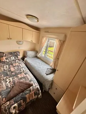 a small bedroom with a bed and a window at 2 Bedroom Caravan Located in Uddingston, Glasgow at Maryville Caravan Site in Uddingston