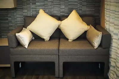 a couch with three pillows on top of it at Benvoulin Bothy - luxury pod with stunning views in Oban
