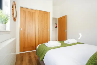 a bedroom with a bed and a wooden door at Castlehill cabin with a hot tub in Peebles