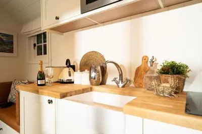 a kitchen with a sink and a counter top at Cosy Cute Cabin with Large Veranda & Outdoor Bath in Glasgow
