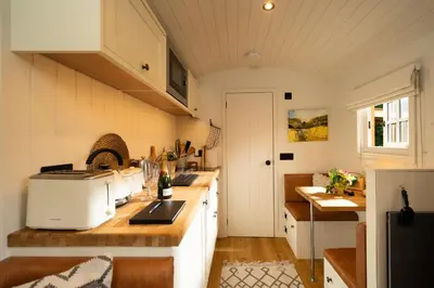 a kitchen with white cabinets and a counter top at Cosy Cute Cabin with Large Veranda & Outdoor Bath in Glasgow