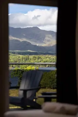 a bench sitting in front of a view of a lake at New Build Lodge With Stunning Views of Loch Awe in Hayfield