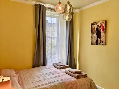 a bedroom with a bed and a window with towels on it at Cosy one bedroom flat in city center in Edinburgh