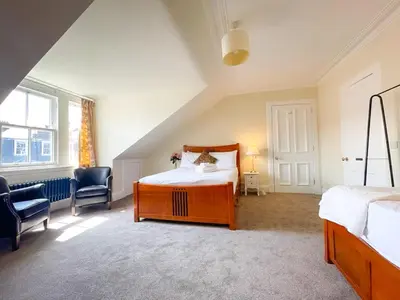 a bedroom with a bed and a desk and a chair at Remarkable 5BR Townhouse with Garden, Sleeps 12 in Edinburgh