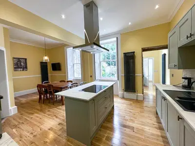 a kitchen and dining room with a table and a kitchen island at Remarkable 5BR Townhouse with Garden, Sleeps 12 in Edinburgh
