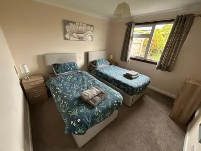 a bedroom with two beds and a window at Viewlands house in Auchterarder