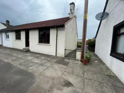 a white building with a pole next to a street at Viewlands house in Auchterarder