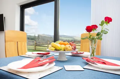 a blue table with a plate of fruit on it at Shiphorns luxury cabin with a hot tub in Eddleston
