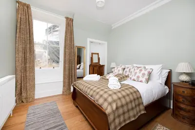 a bedroom with a bed and a window at JOIVY Cozy Apt near Edinburgh Castle in Edinburgh