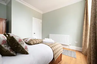 a bedroom with a bed with pillows and a window at JOIVY Cozy Apt near Edinburgh Castle in Edinburgh