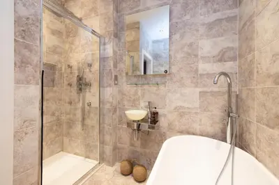 a bathroom with a shower and a tub and a sink at JOIVY Cozy Apt near Edinburgh Castle in Edinburgh