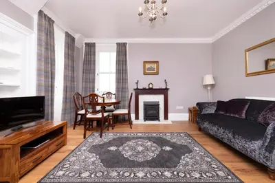 a living room with a couch and a table at JOIVY Cozy Apt near Edinburgh Castle in Edinburgh
