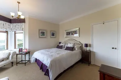 a bedroom with a bed and a couch and a window at St Michael's in Kippen