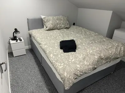 a bed with a black bag sitting on top of it at Nelson st (YELL) in Largs