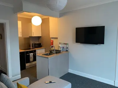 a living room with a kitchen with a sink at Nelson st (YELL) in Largs
