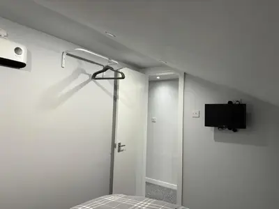 a white room with a bed and a tv on the wall at Nelson st (YELL) in Largs