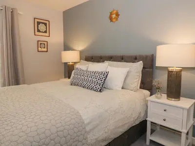 a bedroom with a bed and a nightstand with two lamps at Greystones Cottage in Crieff