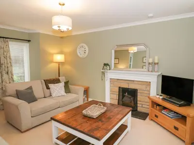 a living room with a couch and a fireplace at Greystones Cottage in Crieff