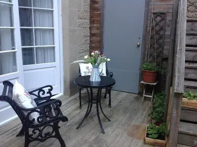 a table with a vase of flowers on a porch at A Room in the City - West in Edinburgh