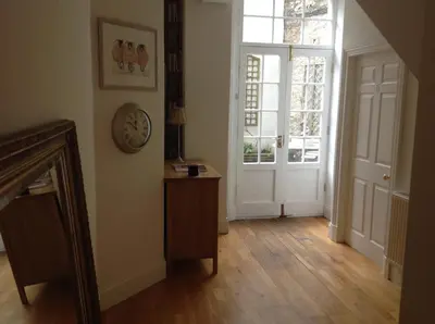 a hallway with a clock on the wall and a door at A Room in the City - West in Edinburgh