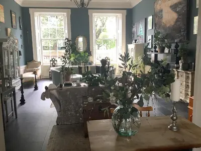 a living room with a vase of flowers on a table at A Room in the City - West in Edinburgh