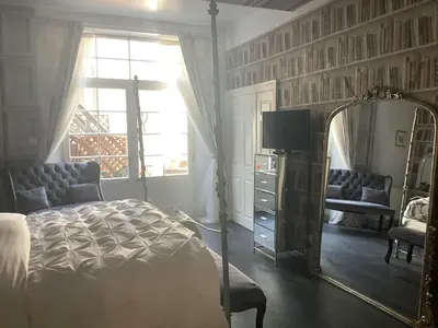 a bedroom with a bed and a mirror at A Room in the City - West in Edinburgh