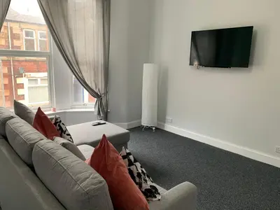 a living room with a couch and a flat screen tv at Nelson st (ANNAN) in Largs