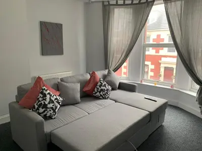 a living room with a couch in front of a window at Nelson st (ANNAN) in Largs