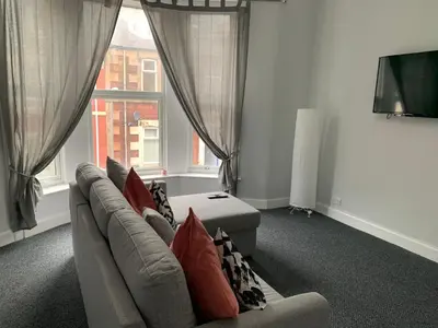 a living room with a couch and a window at Nelson st (ANNAN) in Largs