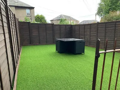 a backyard with green grass and a fence at Nelson st (ANNAN) in Largs