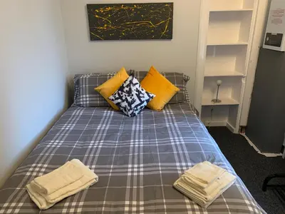 a bed with two pillows and two towels on it at Nelson st (ANNAN) in Largs