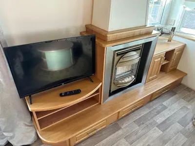 a television sitting on a wooden entertainment center at Willerby Granada 2-Bedroom Located in Uddingston, Glasgow at Maryville Caravan Site in Uddingston