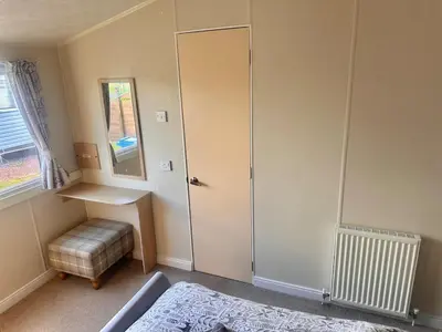 a room with a shower and a door and a stool at Two Bedroom Willerby Caravan Located in Uddingston, Glasgow at Maryville Caravan Site in Uddingston