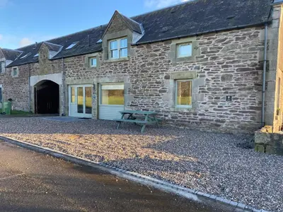 a stone building with a picnic table in front of it at The Granary in Stirling