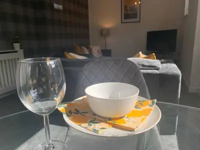 a bowl and a wine glass sitting on a table at Modern 2 bedroom flat with free parking in Cambuslang, Glasgow in Glasgow
