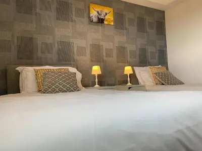 a bedroom with two beds and two lamps at Modern 2 bedroom flat with free parking in Cambuslang, Glasgow in Glasgow