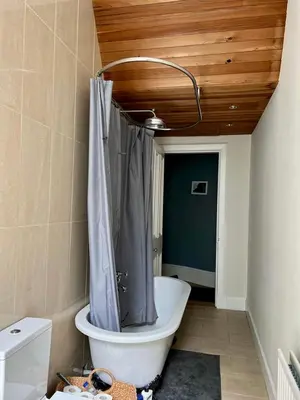 a bathroom with a bath tub with a shower curtain at Beautiful Double Room in Idyllic West End Townhouse in Glasgow