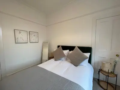 a bedroom with a bed with white sheets and pillows at A Shore Stay in Gourock
