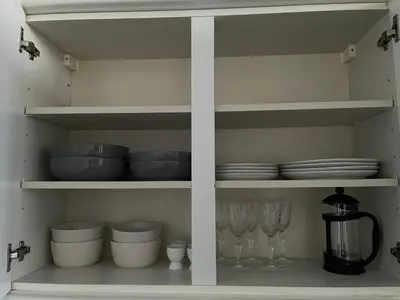 a kitchen shelf with bowls and plates and a blender at A Shore Stay in Gourock